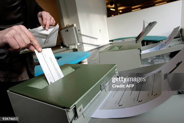 Man casts his ballot at the town hall in Uster, near Zurich on November 29, 2009. Switzerland votes on November 29, 2009 on a controversial call by...