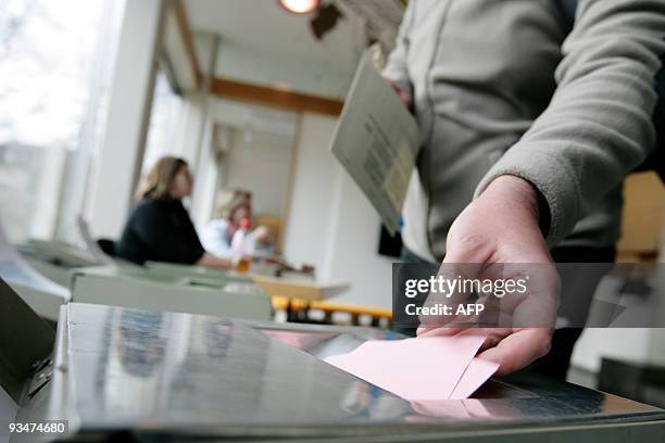 Man casts his ballot at the town hall in Uster, near Zurich on November 29, 2009. Switzerland votes on November 29, 2009 on a controversial call by...
