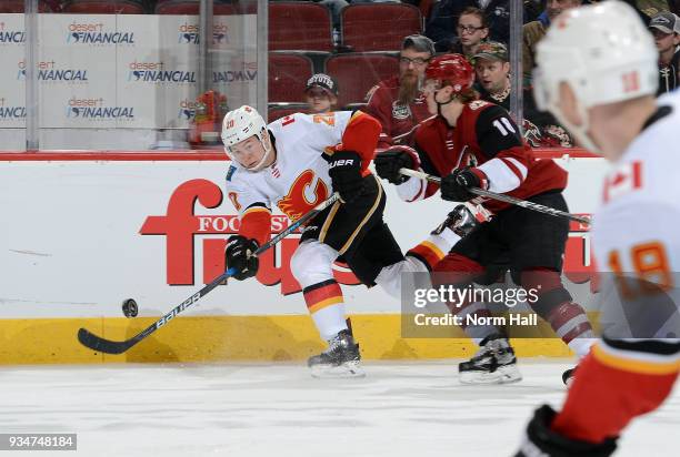 Curtis Lazar of the Calgary Flames passes the puck as Christian Dvorak of the Arizona Coyotes defends during the second period at Gila River Arena on...