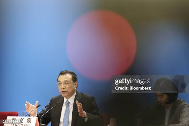 Li Keqiang, China's premier, left, speaks as an interpreter looks on during a news conference following the closing of the First Session of the 13th...