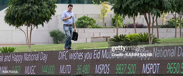 Man walks outside the Dubai International Financial Center in the Gulf emirate on November 29, 2009. Dubai's shock alert of possible debt default...