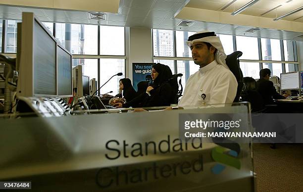 Emirati employees work at the Standard Chartered Bank's new trading room at the Dubai International Financial Center , on April 28 2008.Chartered...