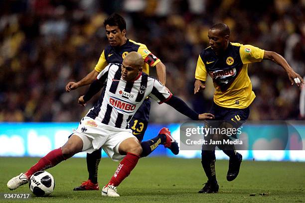 Humberto Suazo of Monterrey vies for the ball with Pavel Pardo and Adolfo Rosinei of America during their Apertura 2009 quarterfinals soccer match at...