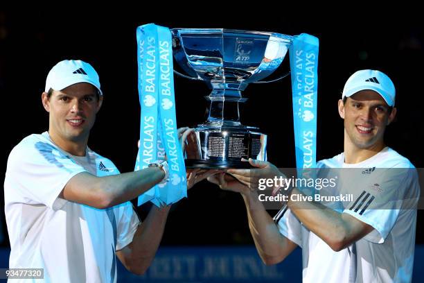 Bob Bryan of USA and Mike Bryan hold the trophy as they celebrate winning the men's doubles final match against Max Mirnyi of Belarus and Andy Ram of...