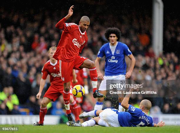 David Ngog of Liverpool is tackled by John Heitinga of Everton during the Barclays Premier League match between Everton and Liverpool at Goodison...