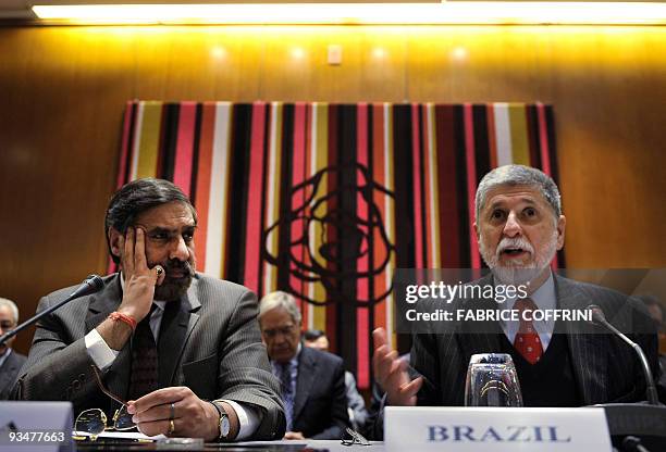 Brazilian Foreign Minister Celso Amorim gestures as he sits beside Indian Commerce and Industry Minister Anand Sharma during a press conference after...