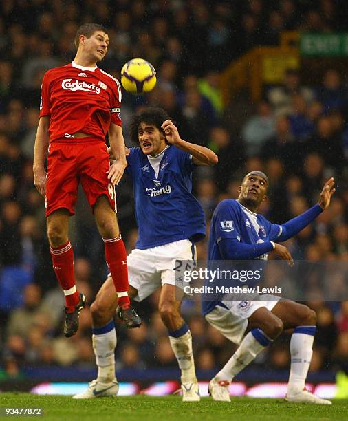 Steven Gerrard of Liverpool competes for the ball with Sylvain Distin and Marouane Fellaini of Everton during the Barclays Premier League match...