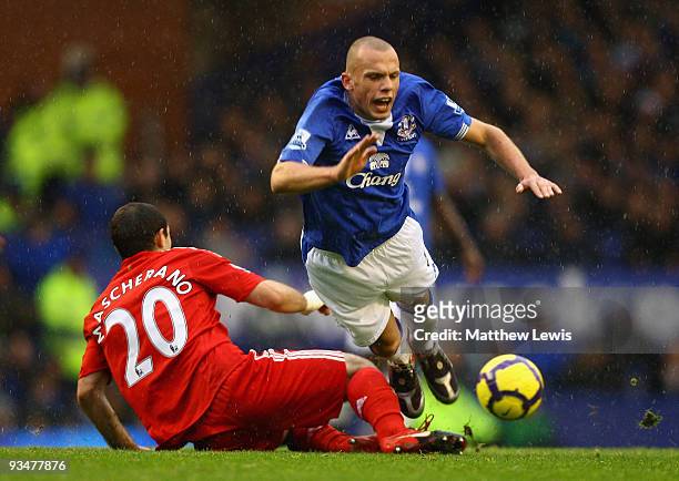Javier Mascherano of Liverpool tackles John Heitinga of Everton during the Barclays Premier League match between Everton and Liverpool at Goodison...