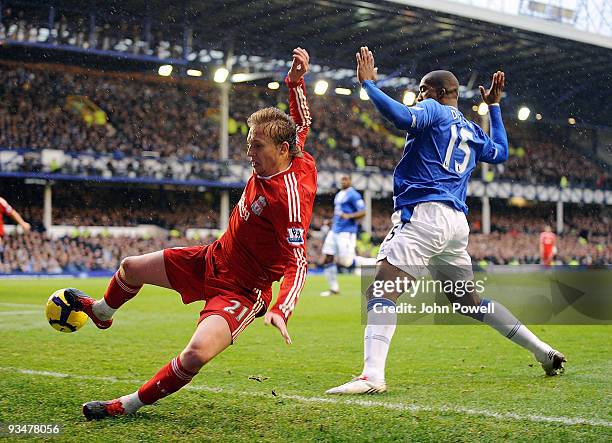 Lucas Levia of Liverpool competes with Sylvain Distin of Everton during the Barclays Premier League match between Everton and Liverpool at Goodison...