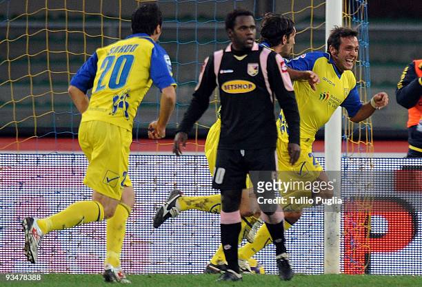 Elvis Abbruscato of Chievo celebrates after scoring the opening goal with his team-mates, as Fabio Simplicio of Palermo reacts during the Serie A...