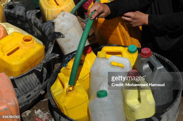 Yemeni people fill their jerrycans with water on March 18, 2018 in Sana'a, Yemen.