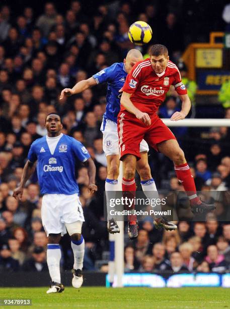 Steven Gerrard of Liverpool goes up with John Heitinga of Everton during the Barclays Premier League match between Everton and Liverpool at Goodison...