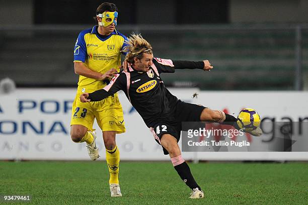 Federico Balzaretti of Palermo holds off the challenge from Erjon Bogdani of Chievo during the Serie A match between AC Chievo Verona and US Citta di...