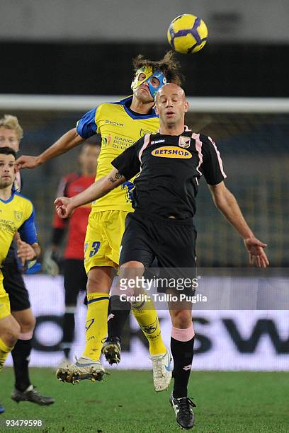 Erjon Bogdani of Chievo and Giulio Migliaccio of Palermo compete for a header during the Serie A match between AC Chievo Verona and US Citta di...