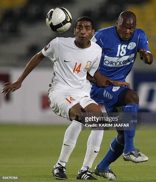 Umm Salal's midfielder Mohammed al-Sayed is challenged by Al-Khuraitiyat's Mozambican defender Dario Ivan Khan as he attempts to head the ball during...
