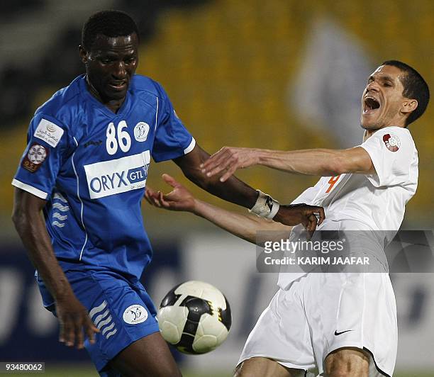 Al-Khuraitiyat's Malian midfielder Suliman Kita challenges Umm Salal's Brazilian forward Magno Alves during their Qatar Stars League football match...