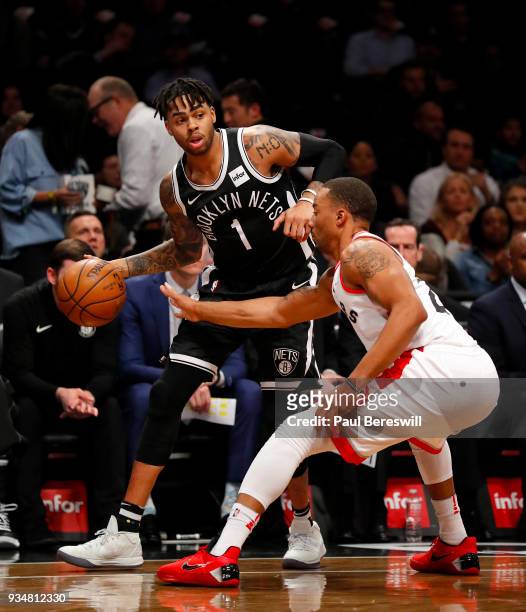 Angelo Russell of the Brooklyn Nets looks to move around Norman Powell of the Toronto Raptors in an NBA basketball game on March 13, 2018 at Barclays...