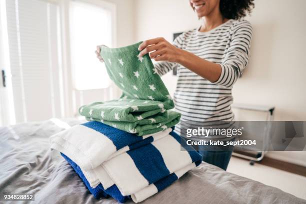 mujer doblando toallas - folding fotografías e imágenes de stock
