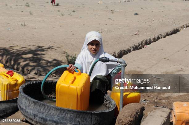 Yemeni girl fills her family's jerrycans with water on March 18, 2018 in Sana'a, Yemen.