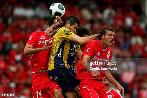 Pablo Aguilar of San Luis vies for the ball with Edgar Duenas and Diego Novaretti of Toluca during their quarterfinals match as part of the 2009...