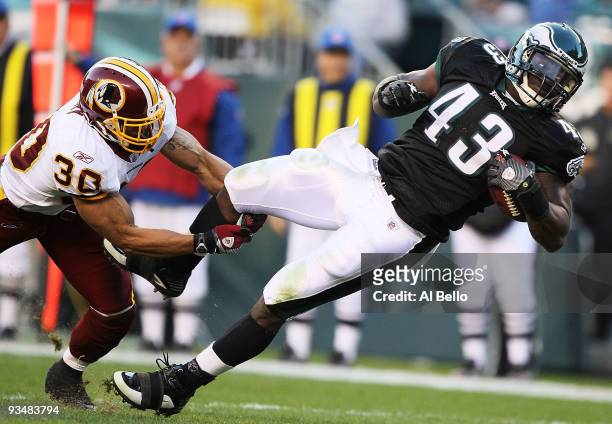 Leonard Weaver of the Philadelphia Eagles is tackled by LaRon Landry of the Washington Redskins during their game at Lincoln Financial Field on...