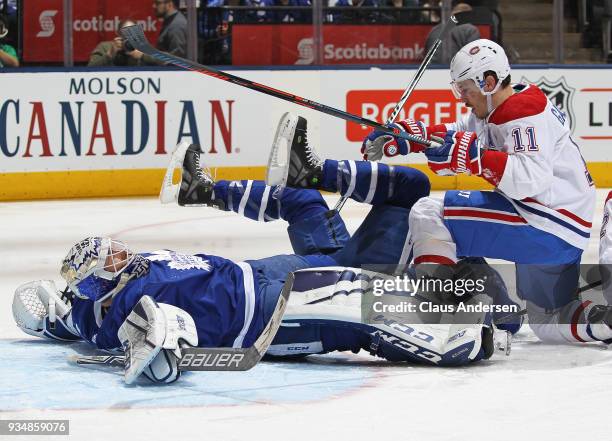 Brendan Gallagher of the Montreal Canadiens slams into Curtis McElhinney of the Toronto Maple Leafs during an NHL game at the Air Canada Centre on...