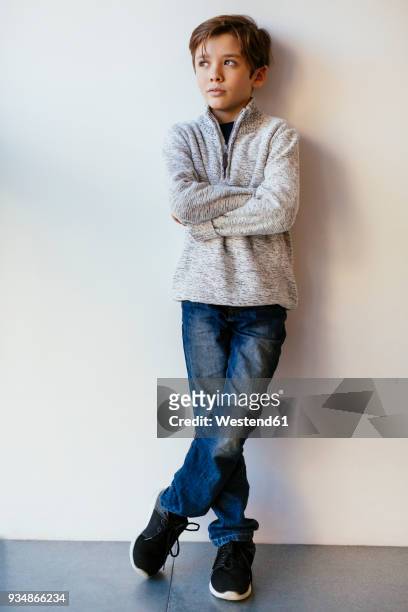 boy leaning against a wall looking away - 10 11 jaar stockfoto's en -beelden