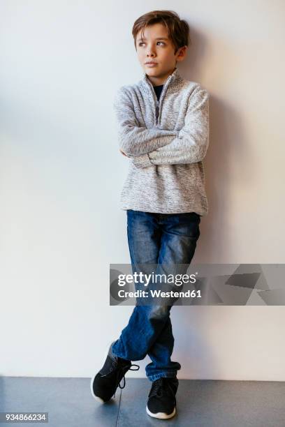 boy leaning against a wall looking away - kids standing crossed arms stock pictures, royalty-free photos & images