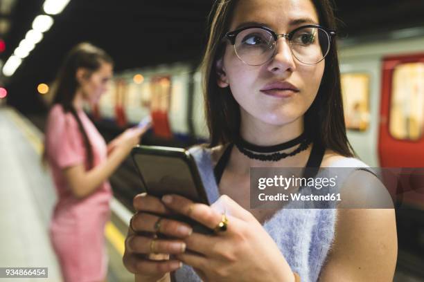 teenage girl using cell phone at subway station - london underground train stock pictures, royalty-free photos & images