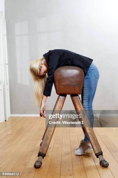 woman leaning on pommel horse - fatigue full body stock-fotos und bilder