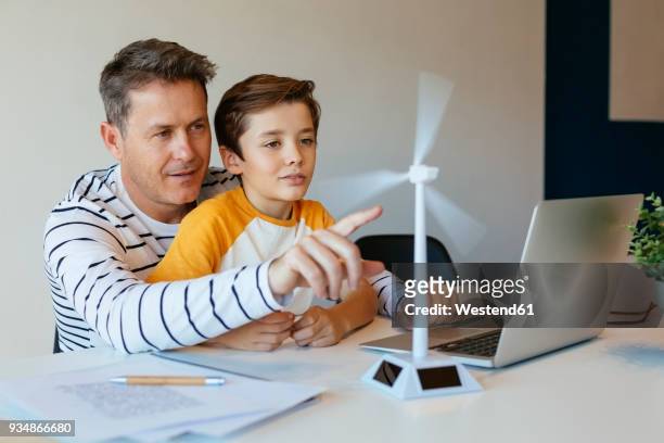 father and son with laptop testing wind turbine model - learning generation parent child stock pictures, royalty-free photos & images