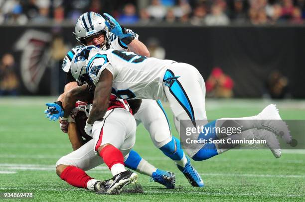 Devonta Freeman of the Atlanta Falcons runs against Thomas Davis and Luke Kuechly of the Carolina Panthers during the first half at Mercedes-Benz...