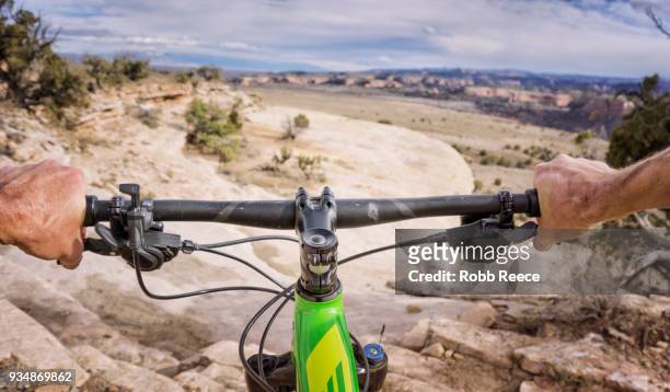 first person view of mountain biker on a desert trail - robb reece stock pictures, royalty-free photos & images