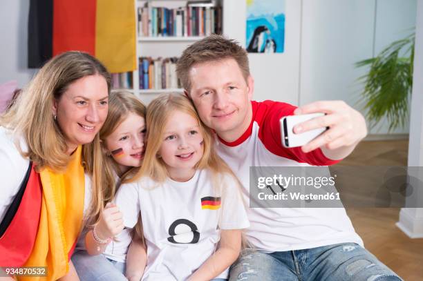 family watching football world cup, taking a smartphone selfie - german film ball 2018 stock-fotos und bilder