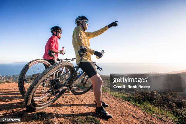 two men with mountain bikes on top of a mountain - robb reece stockfoto's en -beelden
