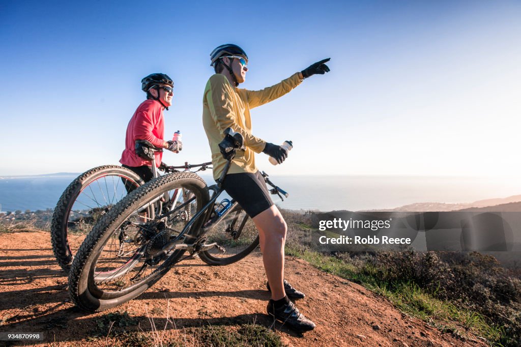 Two men with mountain bikes on top of a mountain