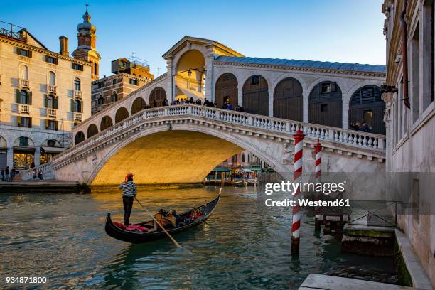 italy, veneto, venice, gondola on canal grande in front of rialto bridge - venetian photos et images de collection