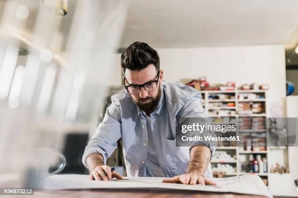 man working on construction plan - architect photos et images de collection