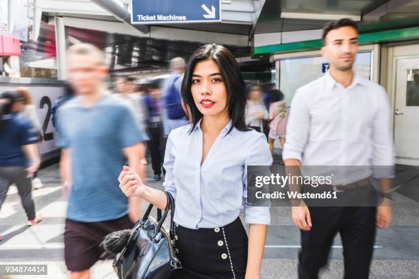 thailand, bangkok, portrait of businesswoman amidst moving people in the city - a separate peace stock pictures, royalty-free photos & images