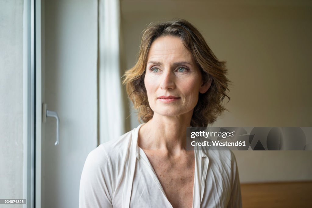 Portrait of pensive mature woman at the window