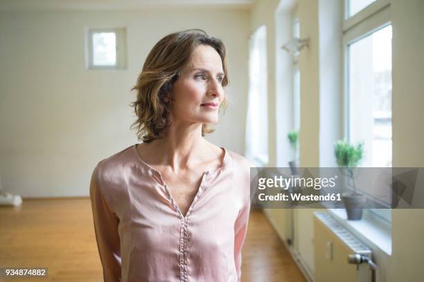 pensive mature woman in empty room - brown hair stock pictures, royalty-free photos & images