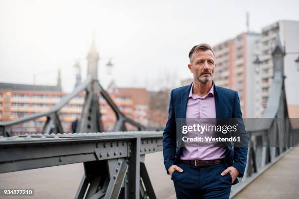 portrait of stylish mature businessman wearing blue suit - three quarter length stock pictures, royalty-free photos & images