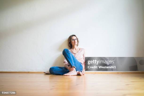 mature woman sitting on floor in empty room thinking - women wearing nothing 個照片及圖片檔