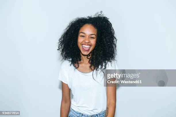 portrait of laughing young woman sticking out tongue - sticking out tongue stock pictures, royalty-free photos & images