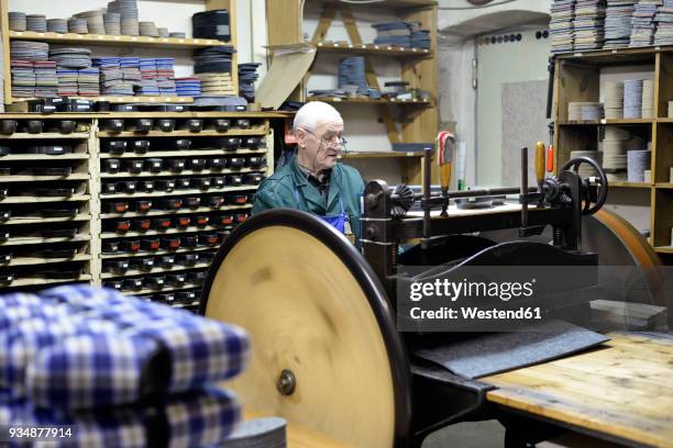 senior shoemaker working with old-fashioned punching machine in workshop - hole punch stock pictures, royalty-free photos & images