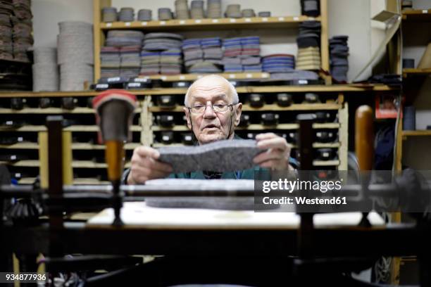 senior shoemaker working with old-fashioned punching machine in workshop - footwear manufacturing stock pictures, royalty-free photos & images