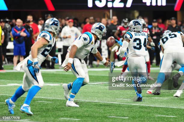 Cam Newton of the Carolina Panthers tosses the ball to Cameron Artis-Payne during the second half against the Atlanta Falcons at Mercedes-Benz...