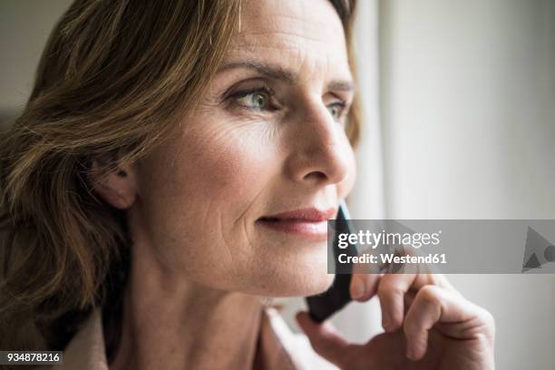 portrait of smiling mature woman on cell phone - 50 54 jahre stock-fotos und bilder