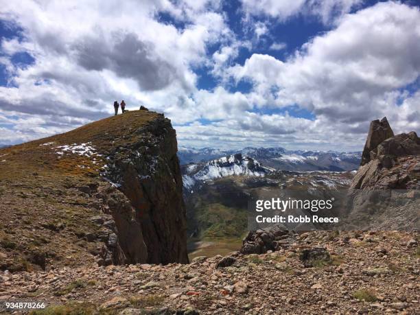 two people standing on a remote mountain top trail - robb reece stock pictures, royalty-free photos & images