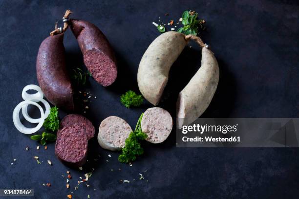 sliced liver sausages and blood sausages, onion rings, parsley and herbs on dark ground - black pudding stock pictures, royalty-free photos & images